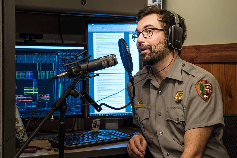 Man recording podcast with microphone and audio equipment