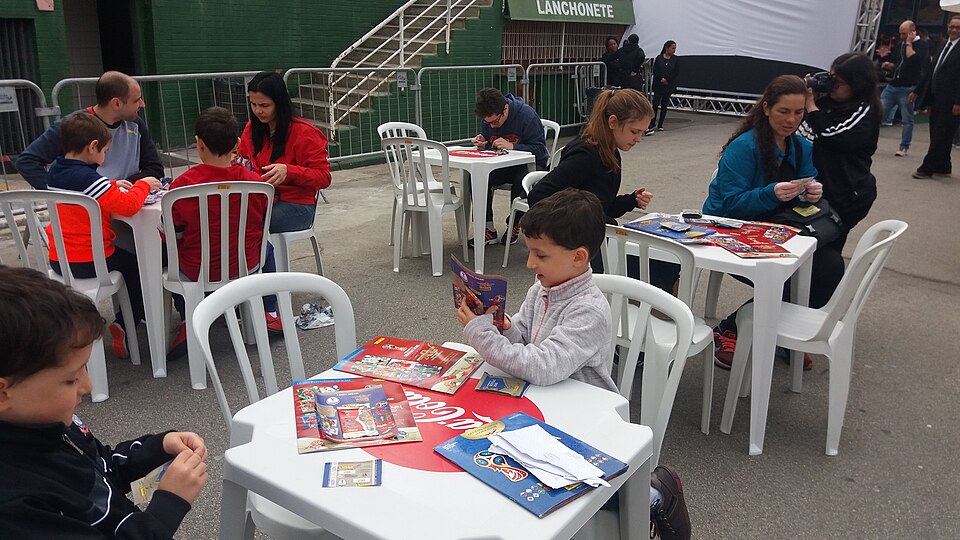 Football fans trading Panini World Cup sticker cards at a collection event