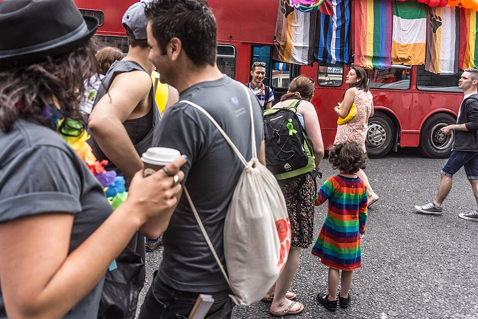 Pride parade participants in colorful outfits celebrating community and music
