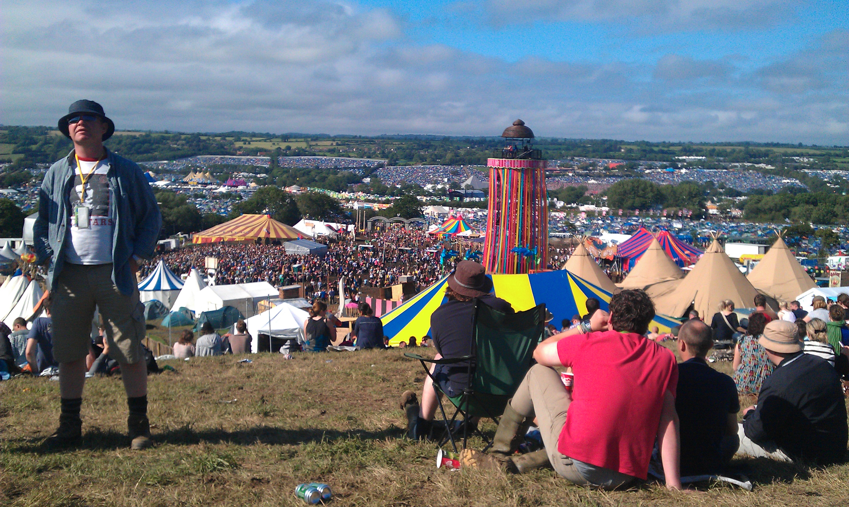 Aerial view of massive Glastonbury Festival crowd gathered around stages on open green fields